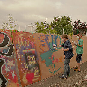 Deux enfants portant un masque sur la bouche étant en train de graffer sur un mur - Agrandir l'image, .JPG 172,0 KB (fenêtre modale)