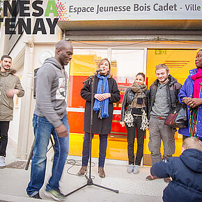des personnes assistant aux propos d'une femme se tenant face à eux, parlant dans un micro - Agrandir l'image, .JPG 232,3 KB (fenêtre modale)